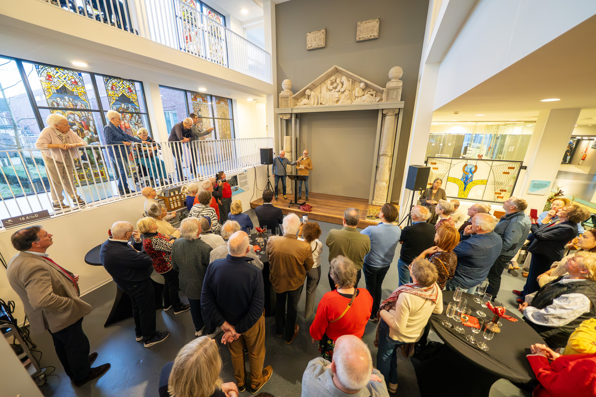 Een groep mensen verzameld bij een presentatie in een museumruimte. Fotograaf Gabor Heeres